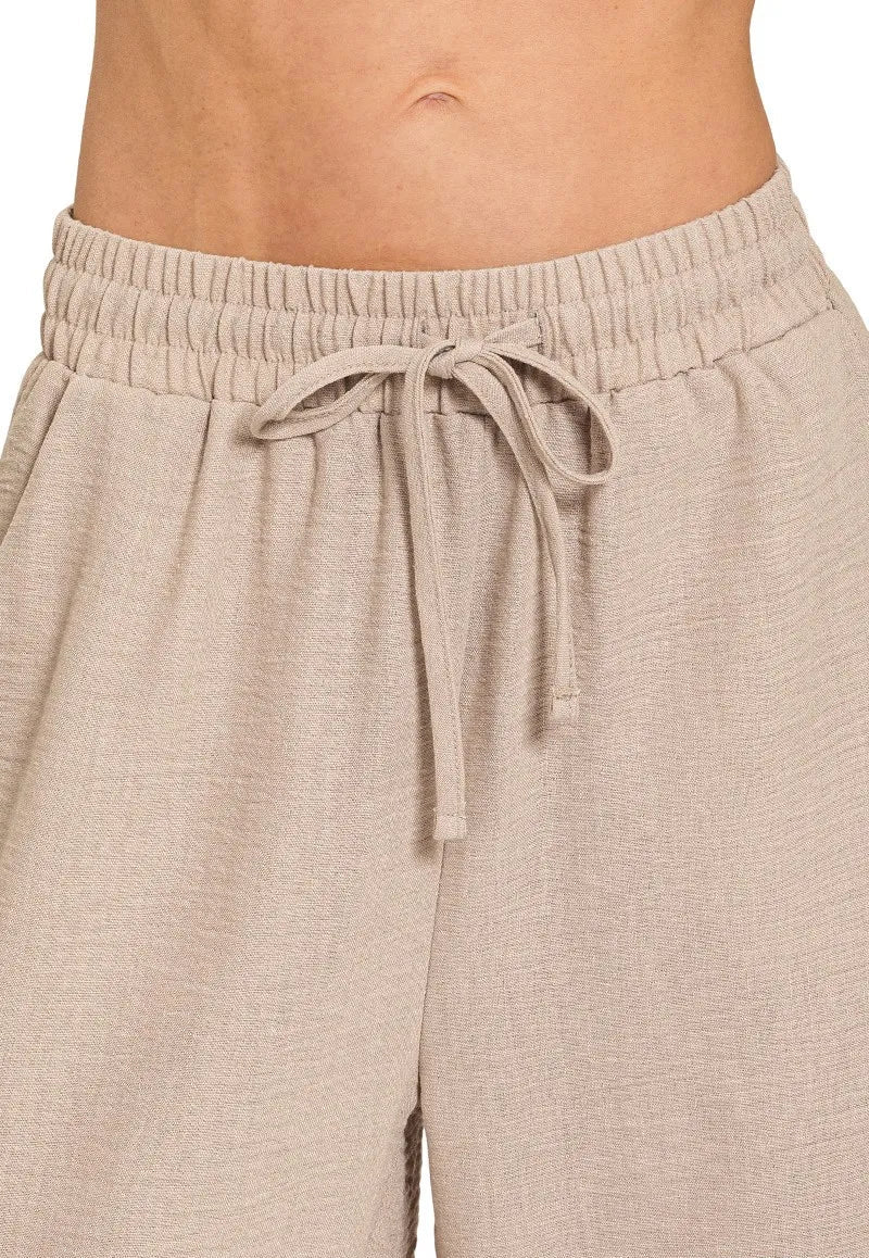 Close-up of beige lounge pants with a drawstring waistband.