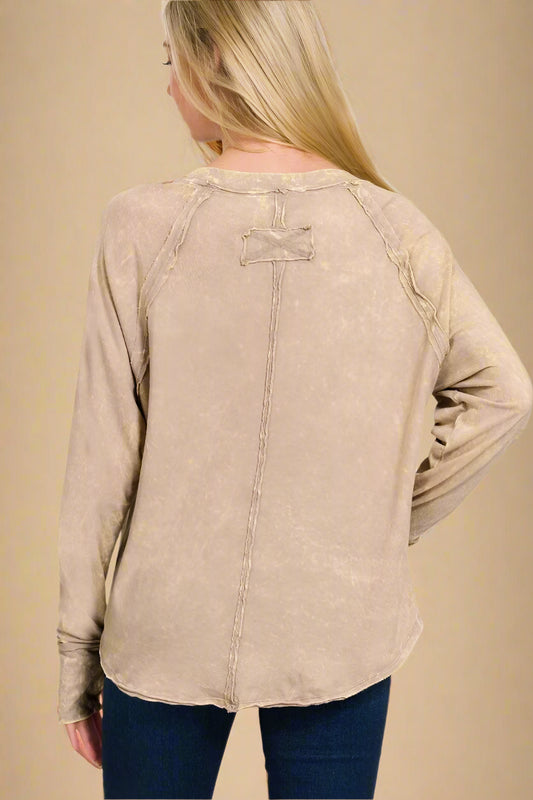 Beige long-sleeve shirt worn by a person on a beige background