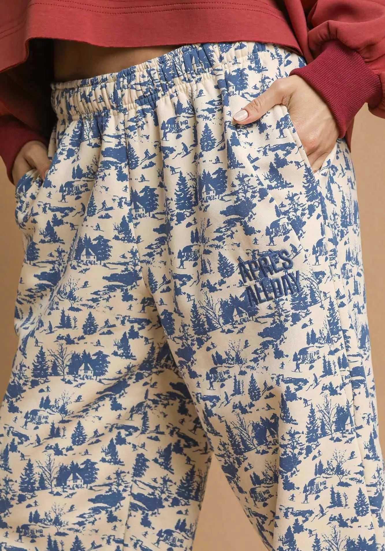 Pants with blue forest pattern and text on a beige background
