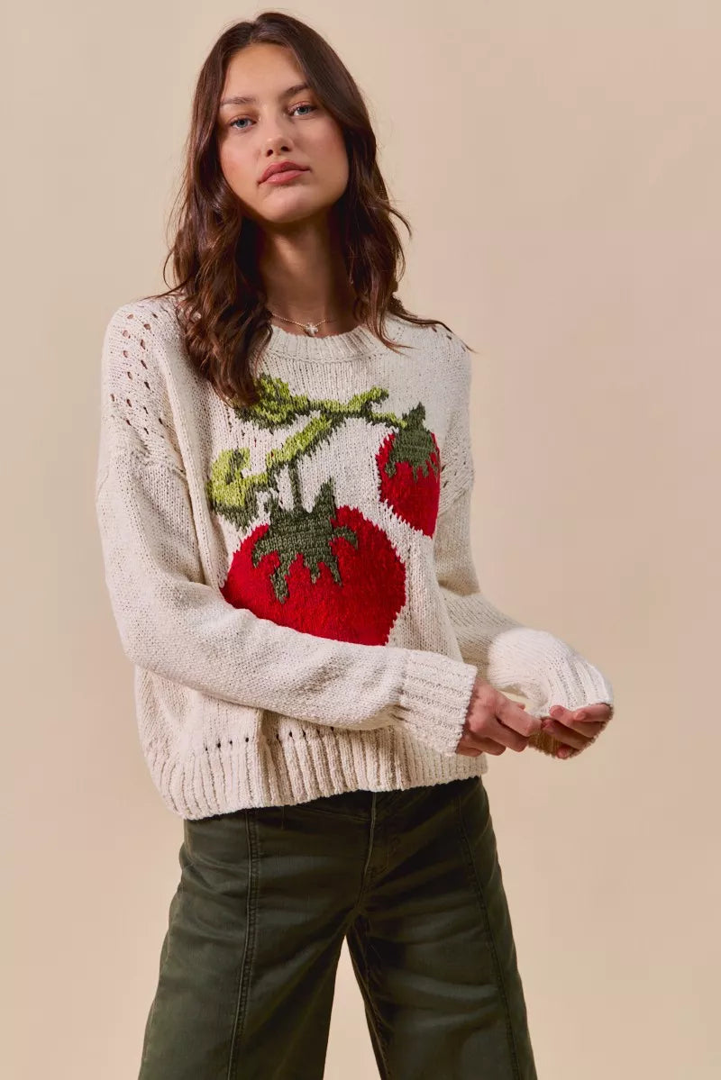 Woman wearing a sweater with red and green designs on a beige background