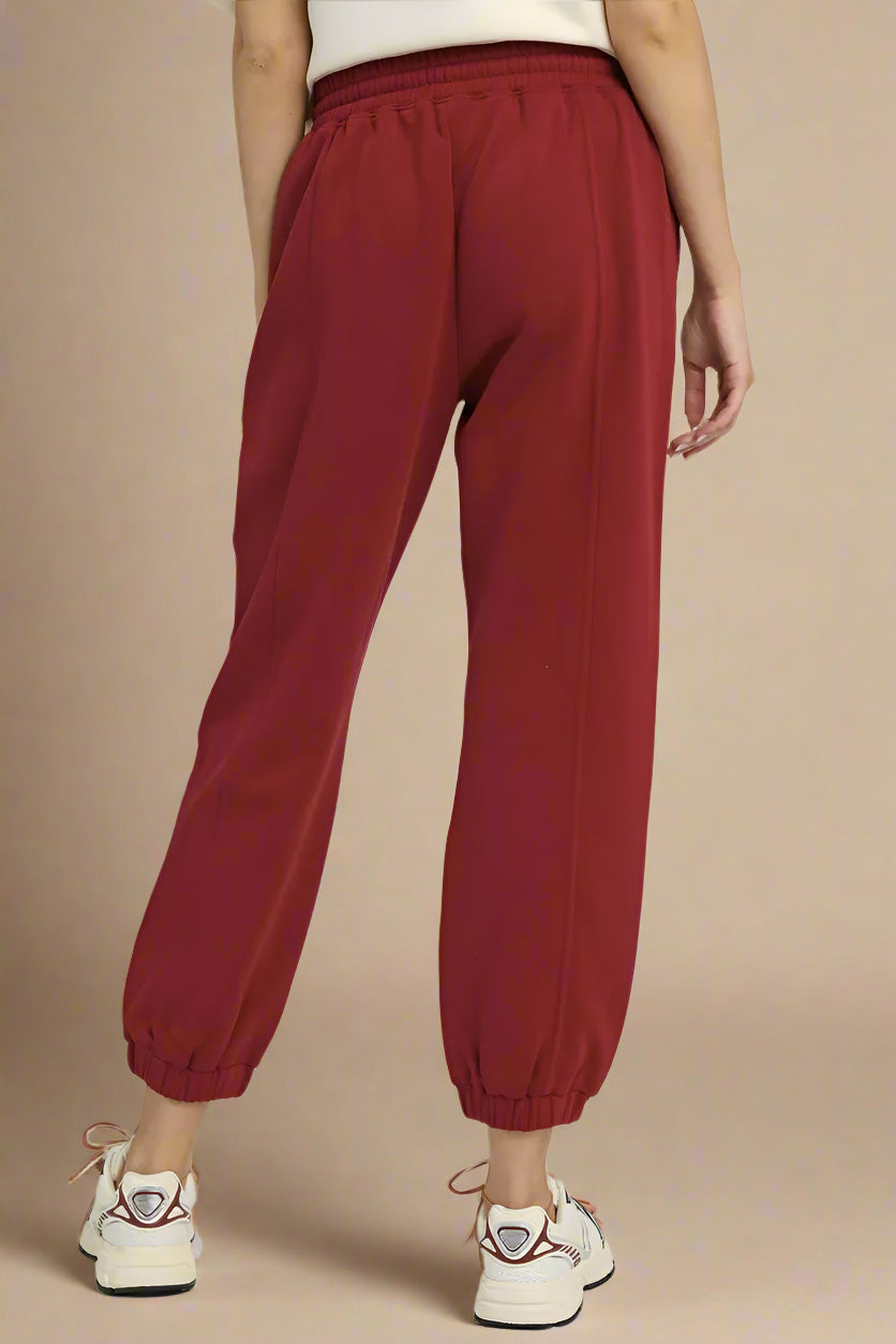 Red jogger pants worn by a person on a plain background