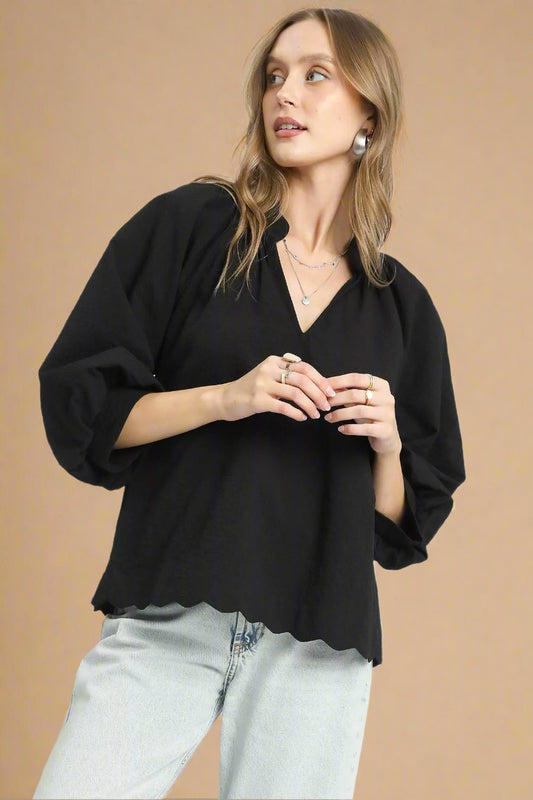 Woman wearing a black blouse and light blue jeans on a white background