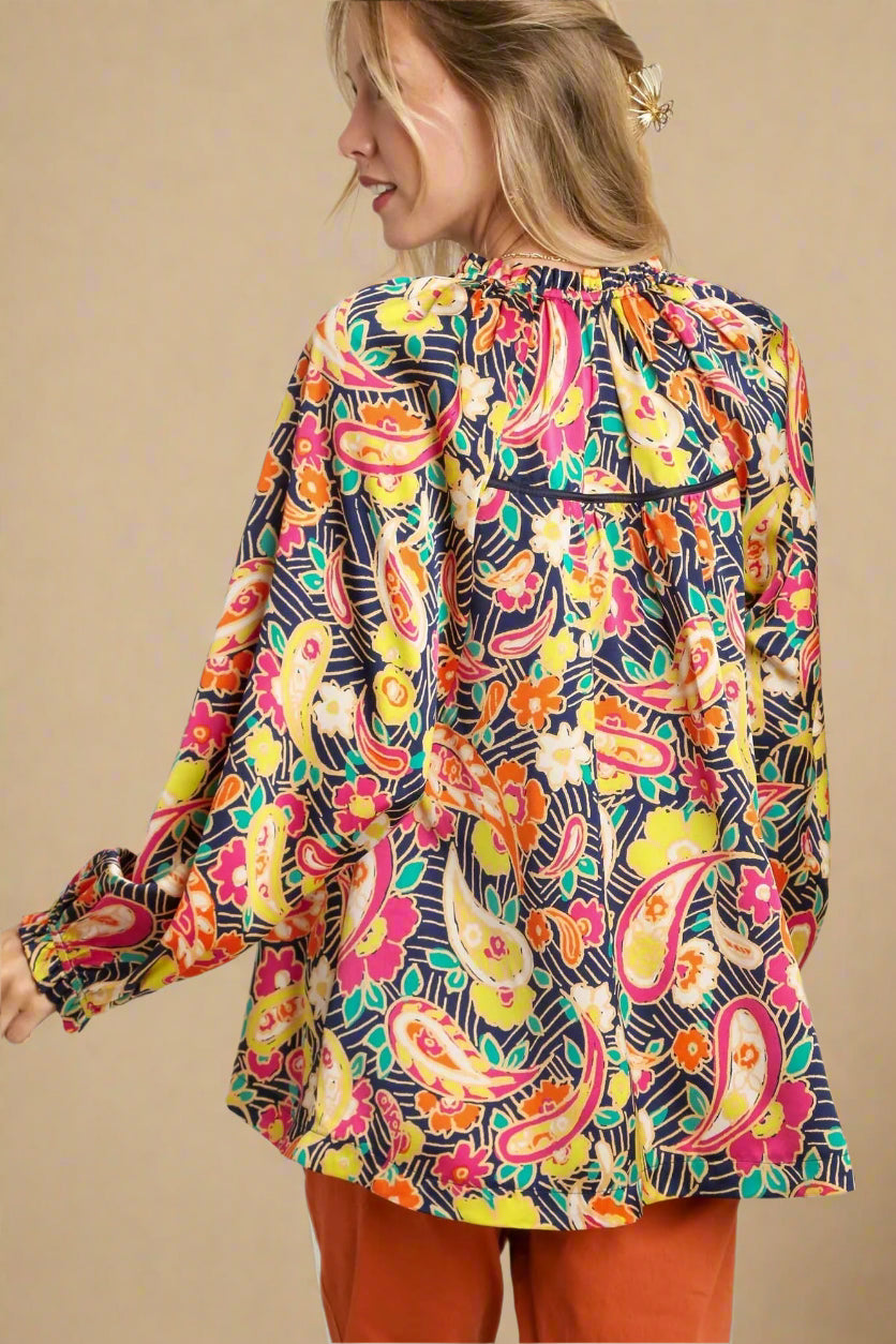 Woman wearing a colorful patterned jacket on a plain background