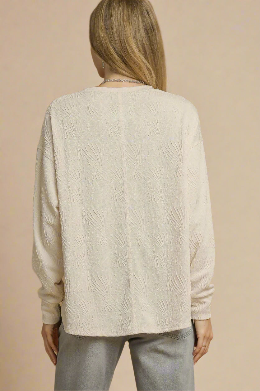 Woman wearing a beige sweater against a beige background