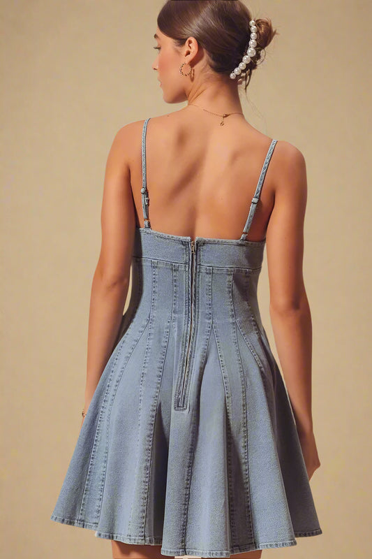 Woman wearing a denim dress with thin straps on a beige background