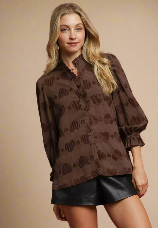Woman wearing a brown patterned blouse and black skirt on a red background