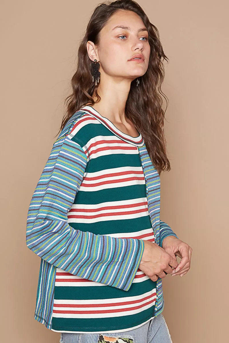 Woman wearing a multicolored striped shirt against a beige background
