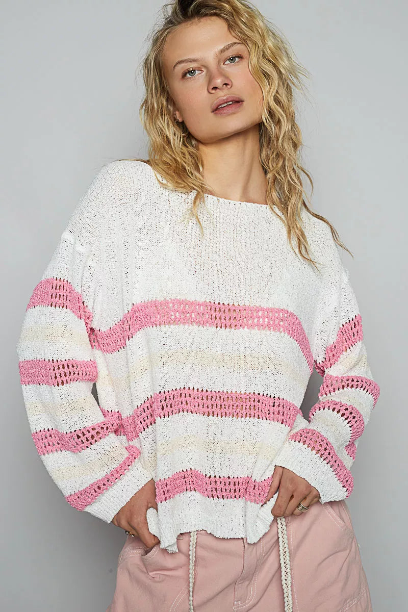 Woman wearing a white and pink striped sweater against a gray background