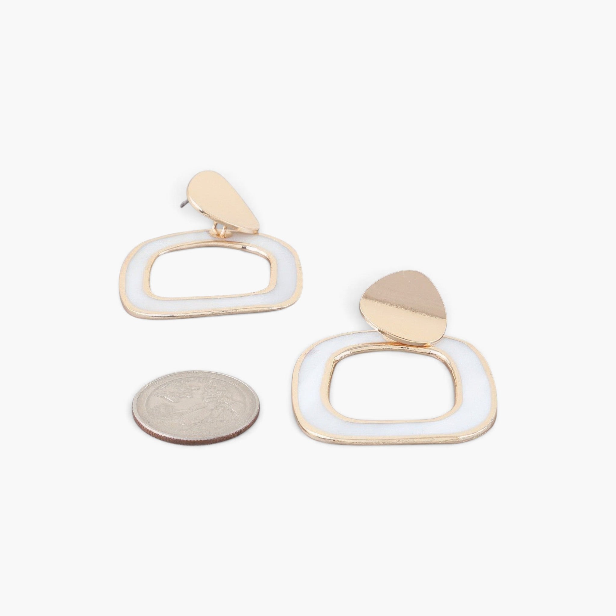 Beach Rose Co. abstract marble frame earrings in gold and cream with a geometric design shown next to a US quarter.