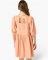 Beach Rose Co. apricot babydoll dress with a square neckline, puff sleeves, and an open back with an adjustable tie.