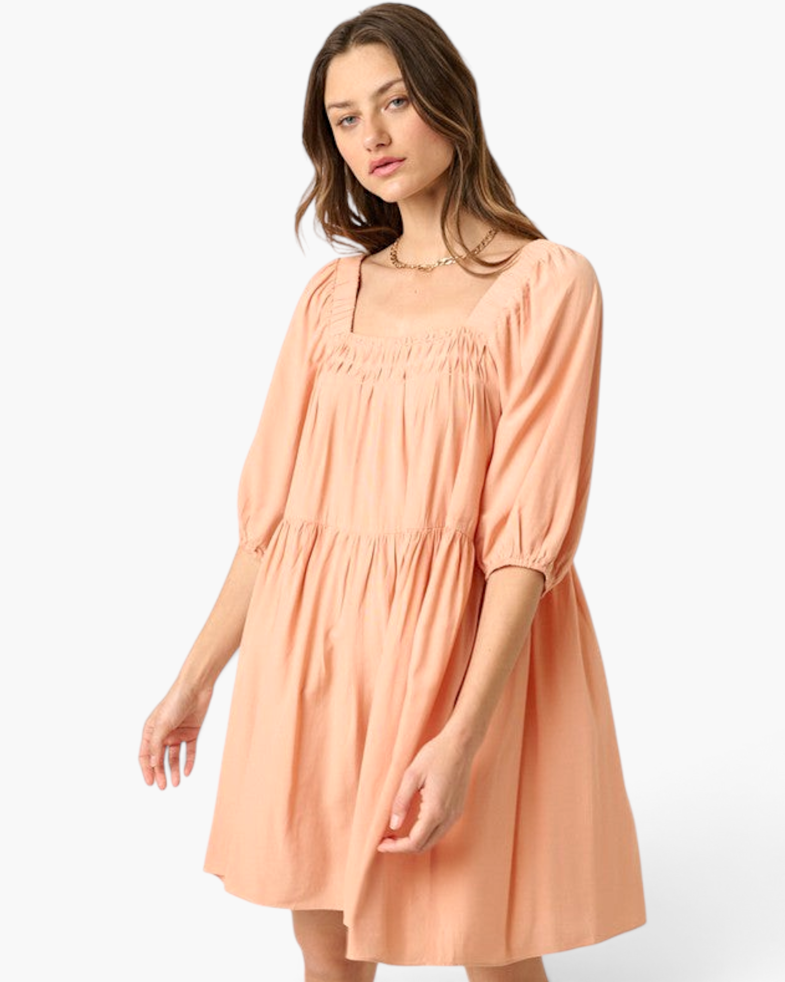Model wearing a Beach Rose Co. apricot babydoll dress with a smocked square neckline and puff sleeves