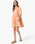 Beach Rose Co. apricot babydoll dress with smocked square neckline, puff sleeves, and tiered skirt on a model.