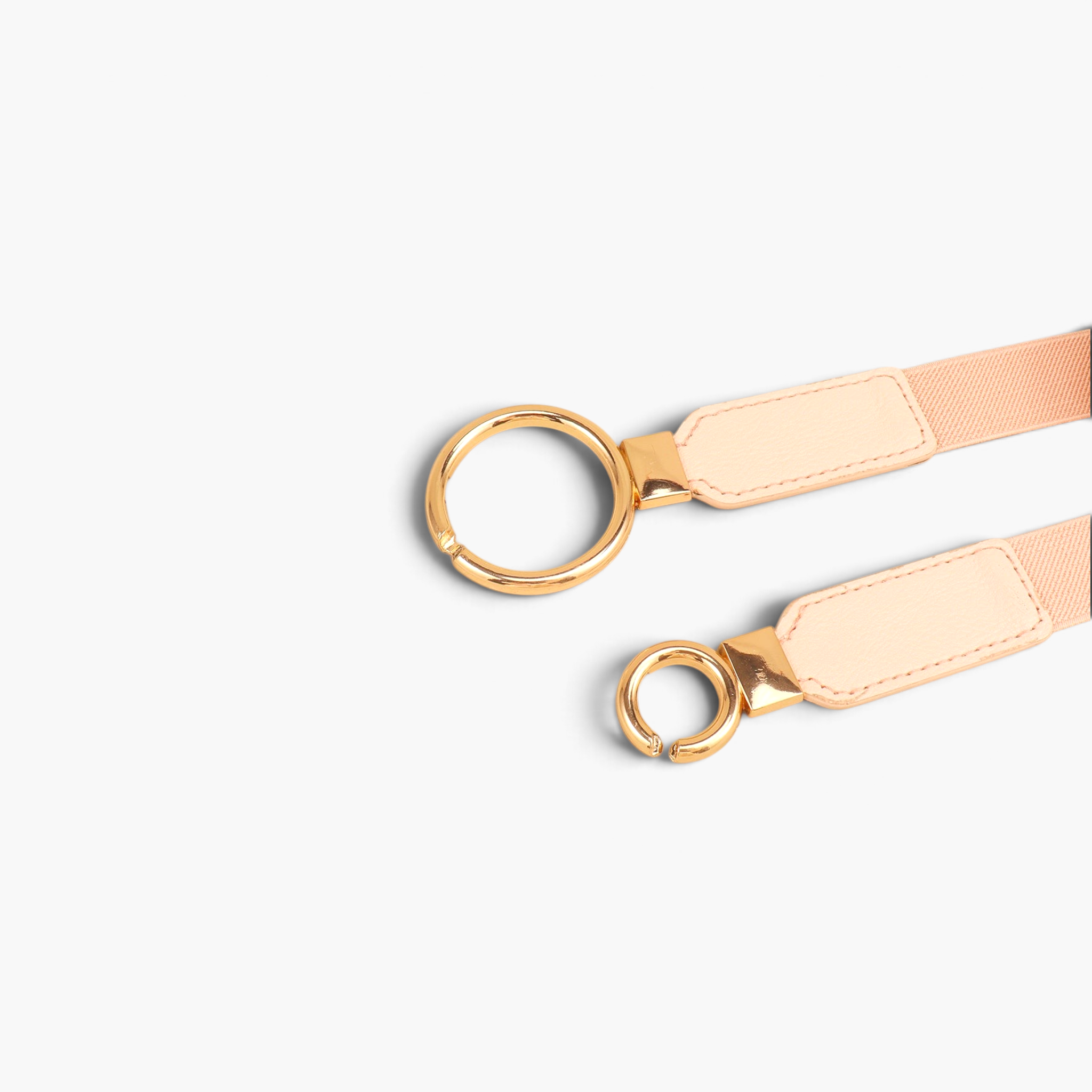 Beach Rose Co. slim elastic waist belt featuring an asymmetric gold double-ring buckle and beige PU leather tabs.