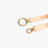 Beach Rose Co. slim elastic waist belt featuring an asymmetric gold double-ring buckle and beige PU leather tabs.
