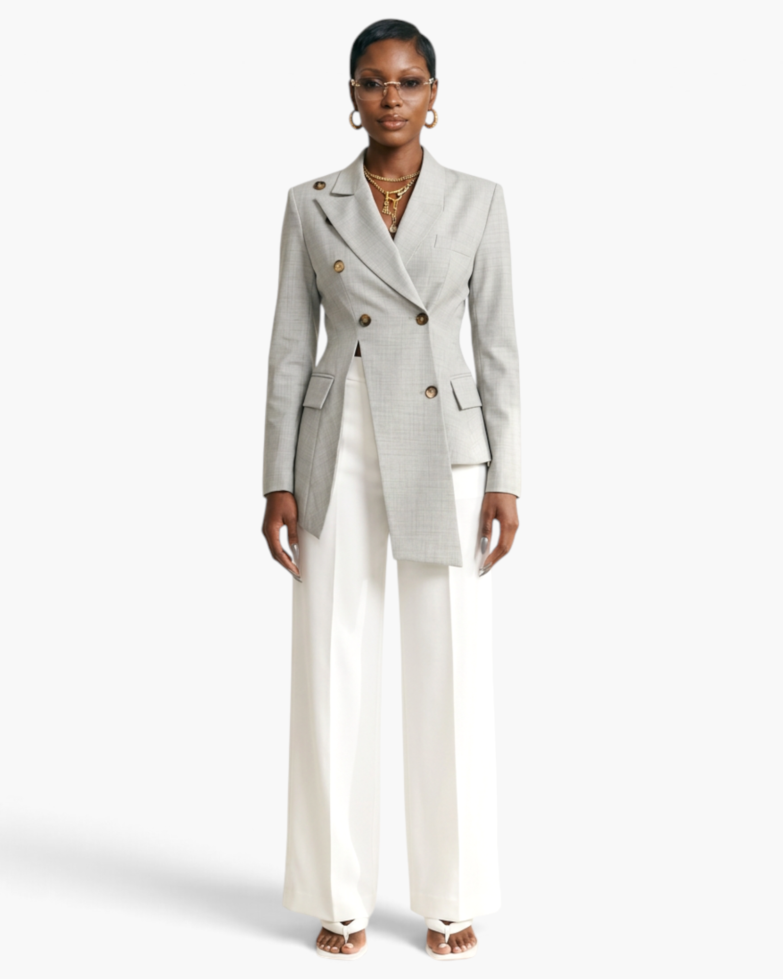 Beach Rose Co. light gray asymmetrical double-breasted blazer with notched lapels worn with white wide-leg trousers.