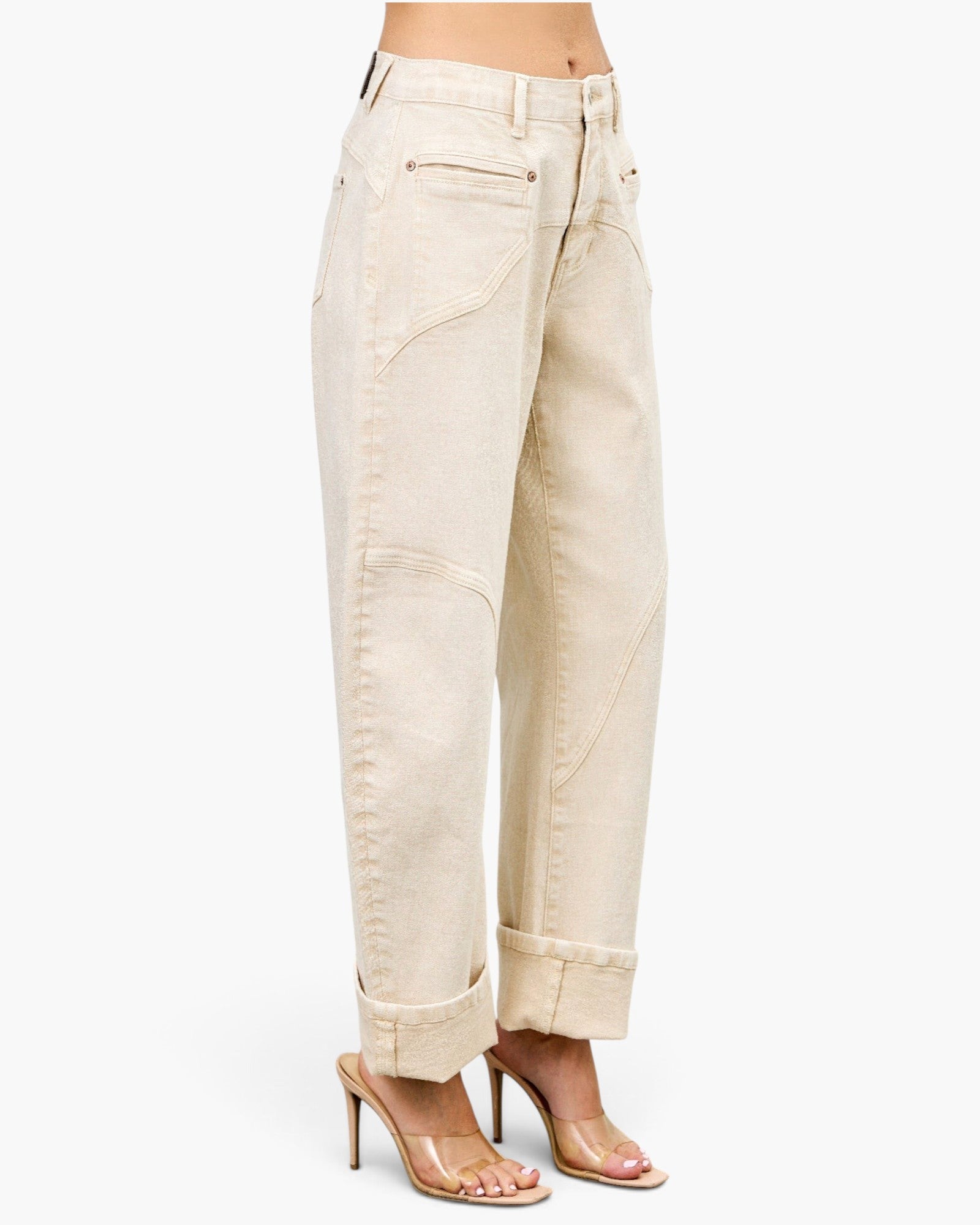 Beach Rose Co. high-rise beige barrel-leg jeans with structured seams and cuffed hems worn with clear heeled sandals.