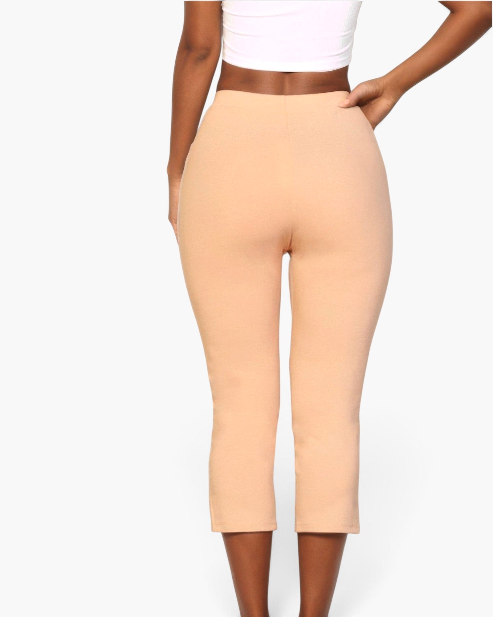 Beach Rose Co. beige cropped pants with elastic waist and slit hem worn by a model on a white background