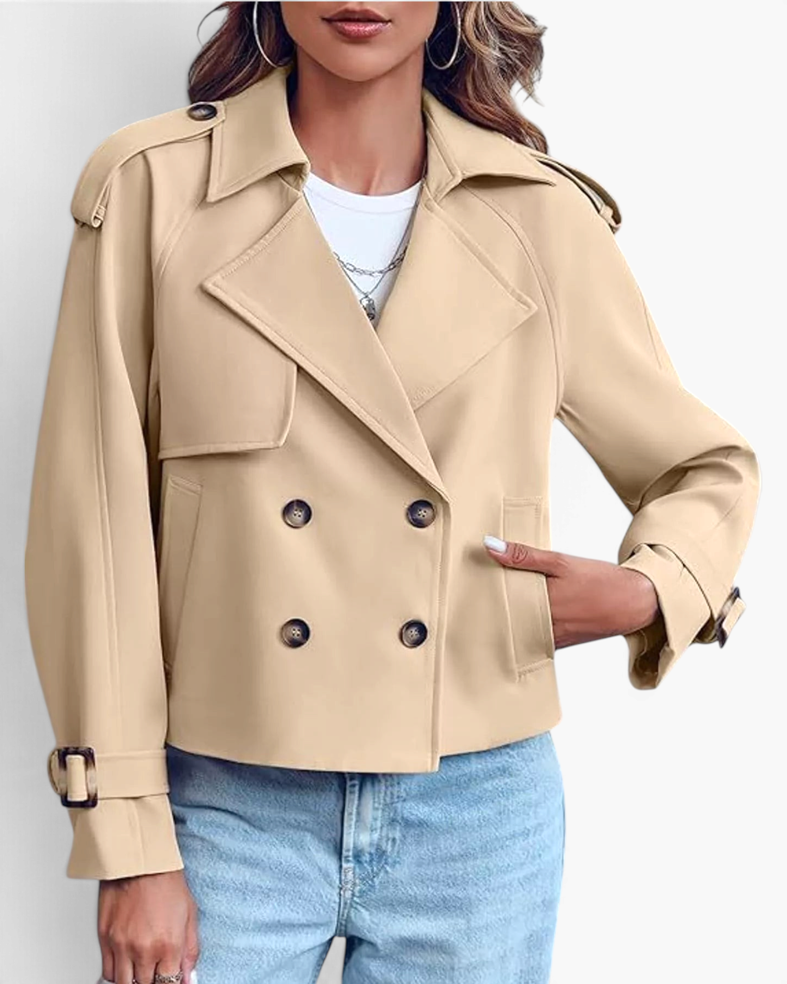 Beach Rose Co. beige cropped double-breasted trench jacket with wide lapels, shoulder tabs, and buckled cuffs.