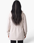 Back view of a Beach Rose Co. beige hooded jacket with an adjustable drawstring waist on a woman with long dark hair.
