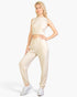 Beach Rose Co. beige French Terry tank top and jogger set worn by a blonde model with white sneakers.
