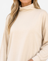 Beach Rose Co. beige long sleeve top with a high neck and relaxed fit, made from soft polyester blend fabric.