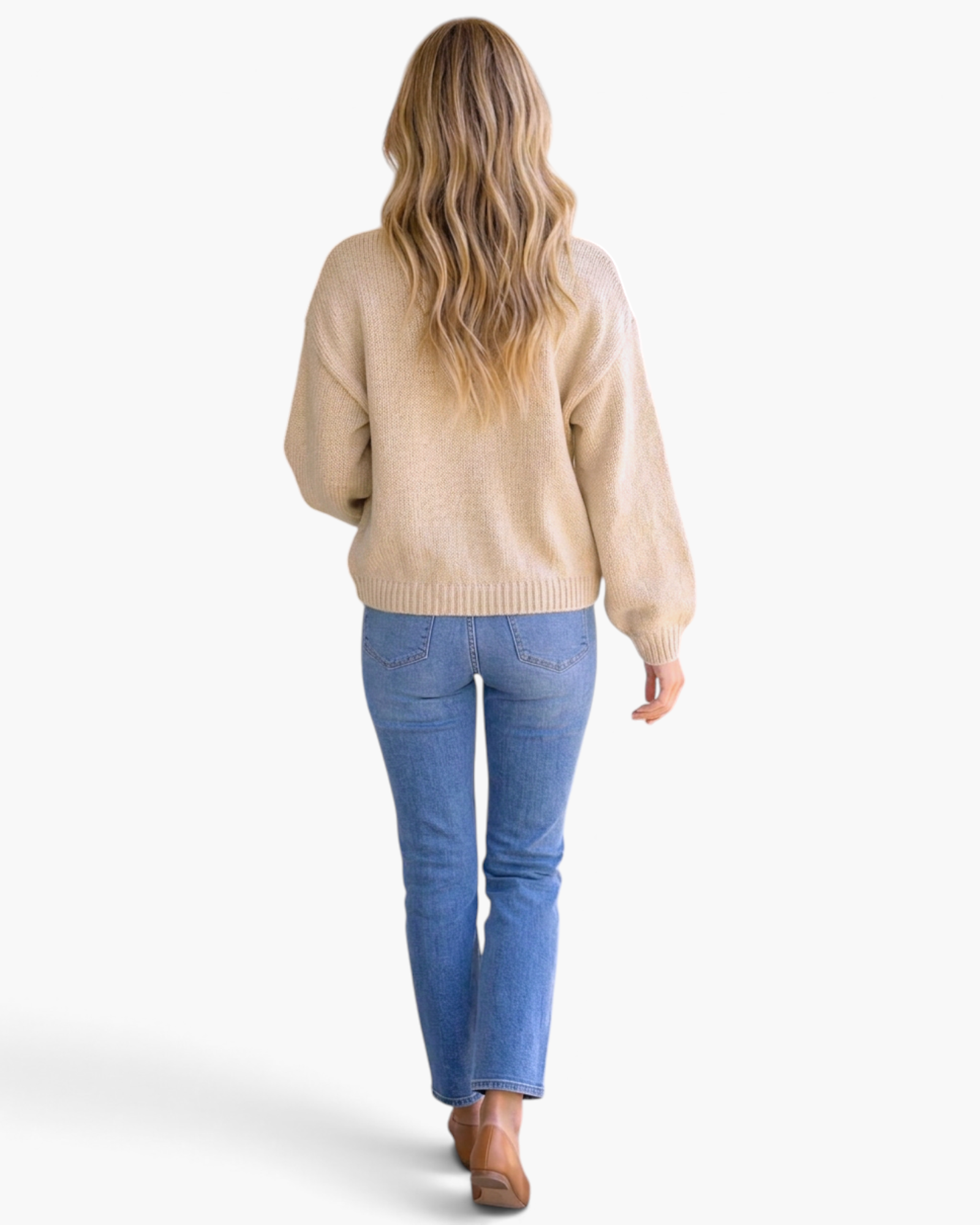 Back view of a woman wearing a Beach Rose Co. beige knit sweater with daisy appliqués and blue jeans