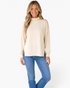 Beach Rose Co. beige long sleeve top with high neck and leopard print split hem detail worn by a smiling model.