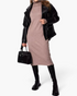 Beach Rose Co. beige midi sweater dress with a ribbed turtleneck, styled with a black leather jacket and boots.