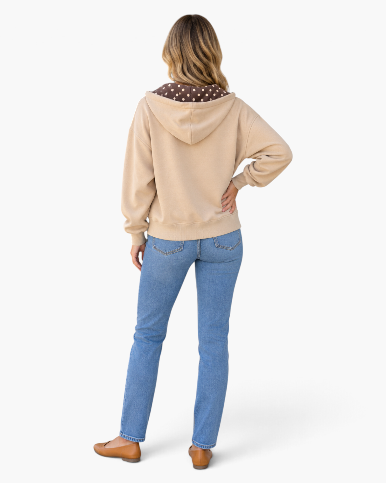 Beach Rose Co. beige zip-up hoodie with brown polka dot hood lining, worn with blue jeans, back view.