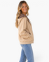 Beach Rose Co. beige zip-up hoodie with brown and ivory polka dot hood lining, worn by a smiling blonde woman.