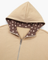Beach Rose Co. beige zip-up hoodie featuring a brown and ivory polka dot lining inside the hood and front opening.