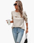Beach Rose Co. beige quilted crewneck pullover with ruffle detail and long sleeves worn by a woman with sunglasses.