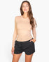 Beach Rose Co. beige ribbed crew-neck long-sleeve top worn by a model with black drawstring shorts
