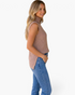 Beach Rose Co. beige sleeveless ribbed knit turtleneck sweater worn by a blonde model with blue jeans, side view.