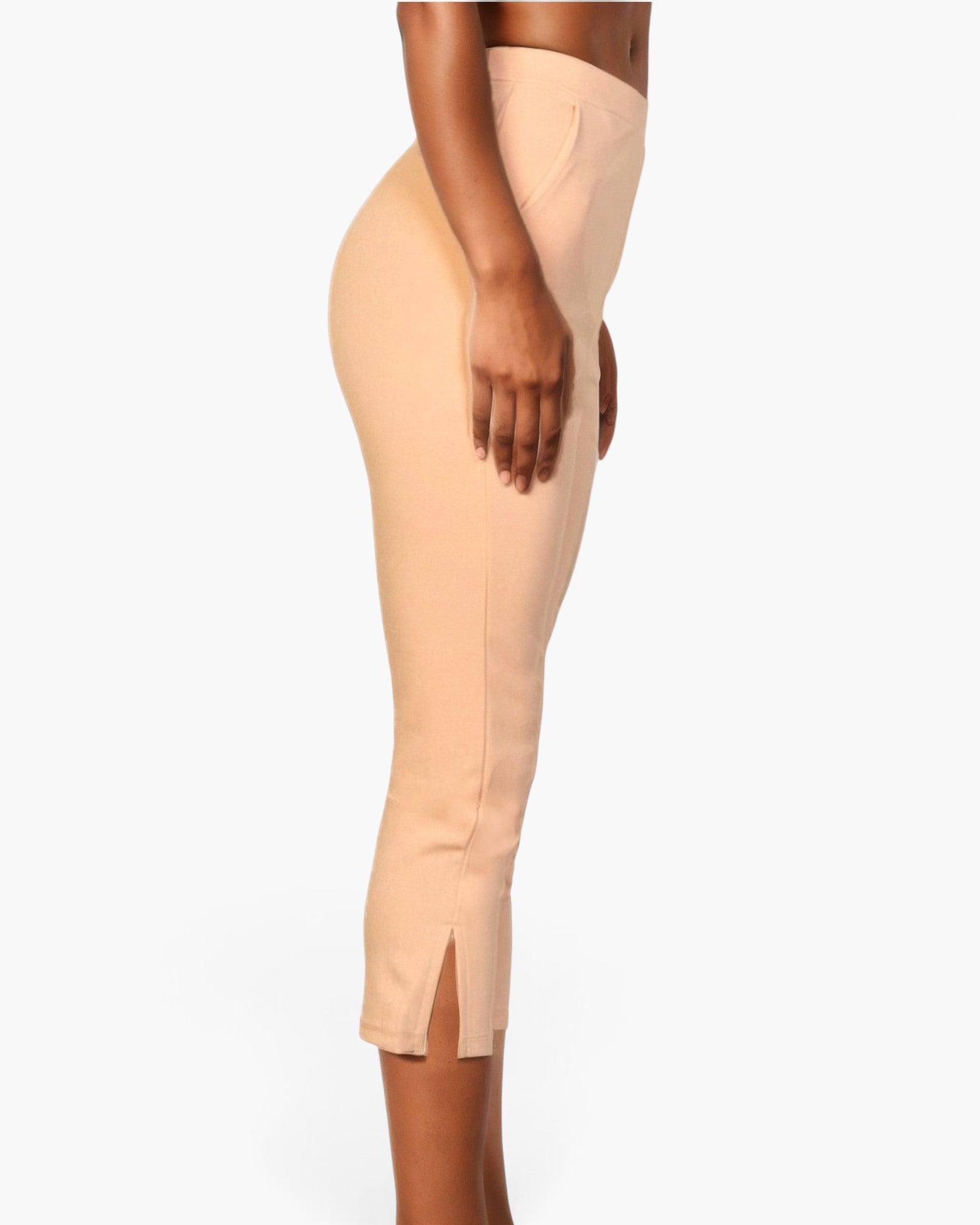Beach Rose Co. beige stretch crepe cropped pants with a side slit hem worn by a model in a side profile view.