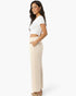 Beach Rose Co. relaxed fit beige wide-leg cotton pants with side pockets worn by a woman in a white crop top