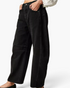Beach Rose Co. black relaxed barrel leg jeans with knee darts and curved side seams worn with a white blouse.