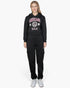 Beach Rose Co. black drop shoulder pullover hoodie with Chicago graphic, worn by a blonde model with black cargo pants.