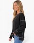 Beach Rose Co. black crewneck sweatshirt with colorful contrast stitching and dropped shoulders on a smiling model