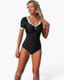 Beach Rose Co. black one-piece swimsuit with white contrast trim, short sleeves, and ruched front detail on a model.