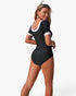 Beach Rose Co. black short-sleeve one-piece swimsuit with white contrast trim on the scoop back and sleeve cuffs.