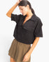 Beach Rose Co. black cotton collared V-neck top with front flap pockets and short sleeves worn by a model