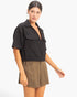 Beach Rose Co. black cotton cropped collared V-neck top with short sleeves and front flap pockets on a model