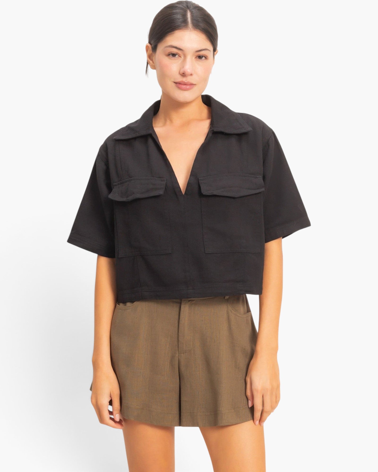 Beach Rose Co. black cotton cropped top with a structured collar, deep V-neck, and two front flap pockets.
