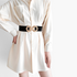 Beach Rose Co. wide black elastic waist belt with a gold double-circle alloy buckle worn over a cream shirt dress.