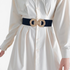 Beach Rose Co. wide black elastic waist belt featuring a gold double-circle alloy buckle worn over a white shirt dress