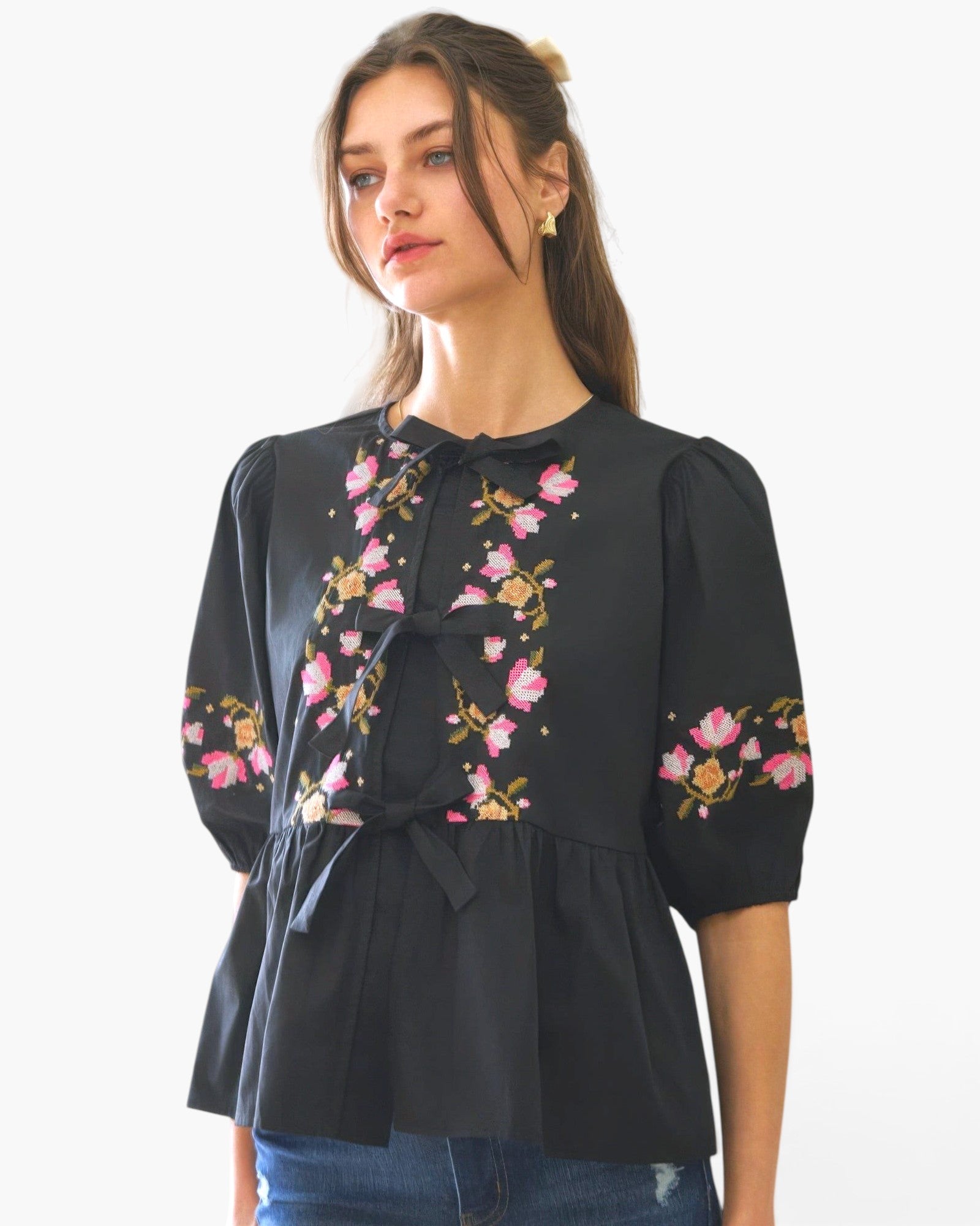 Beach Rose Co. black poplin blouse with pink and yellow floral embroidery, front ribbon ties, and puff sleeves.