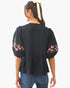 Beach Rose Co. black poplin blouse with puff sleeves, floral embroidery, and a back view of a model with a hair ribbon