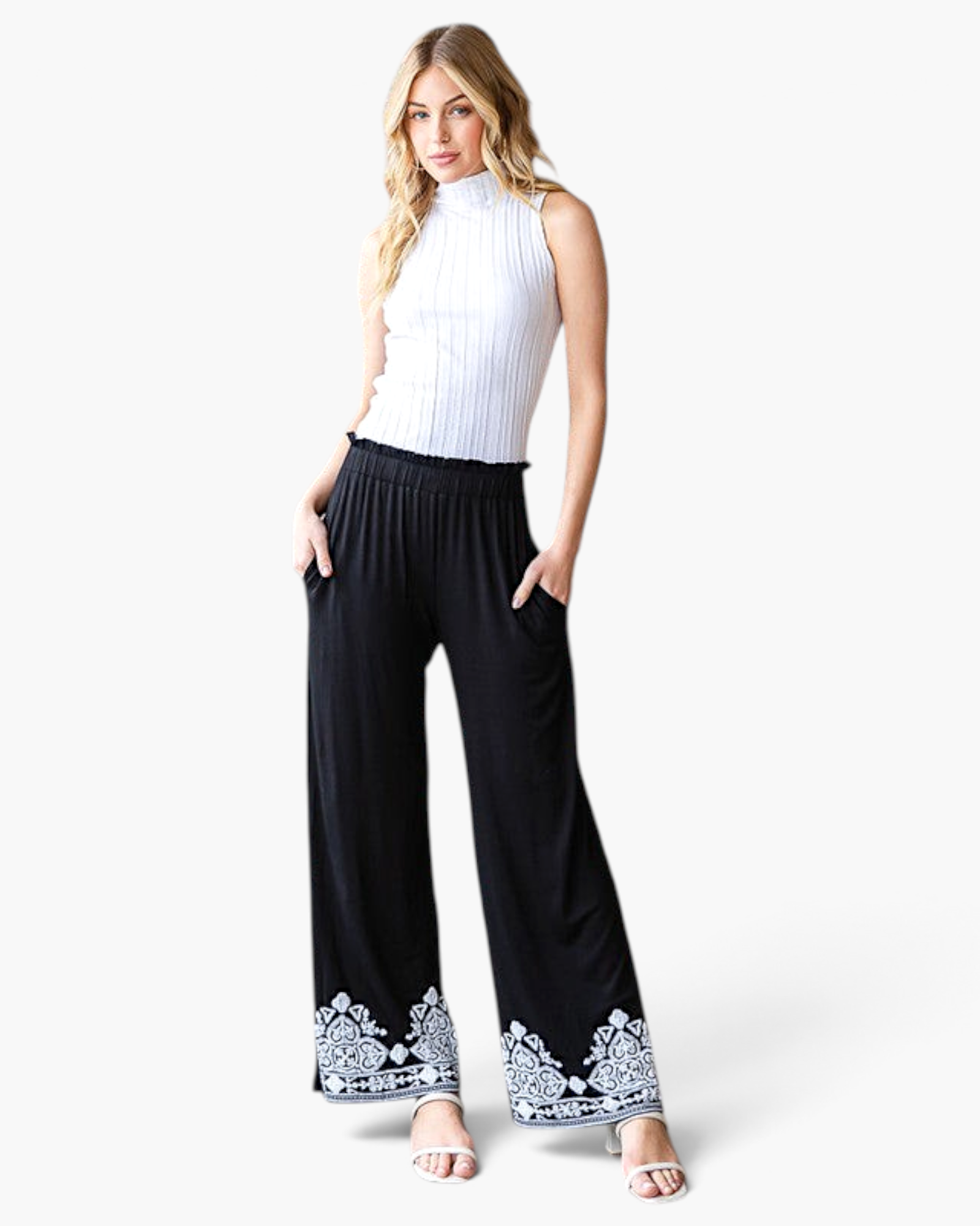 Beach Rose Co. black wide-leg pants with white embroidered hems, elastic waistband, and pockets on a model.