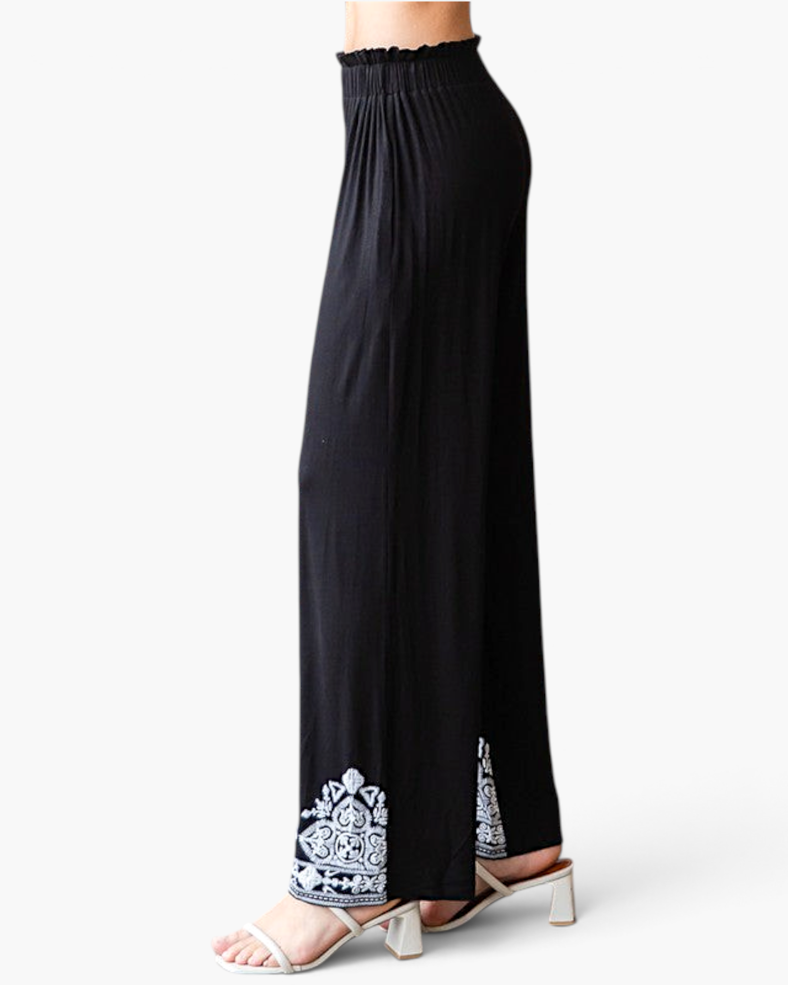 Beach Rose Co. black wide-leg pants with white embroidered hem, elastic waistband, and side view on a model.